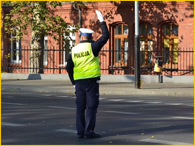 policjant stoi z podniesioną ręką