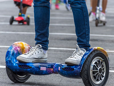 jedzie na deskorolce elektrycznej